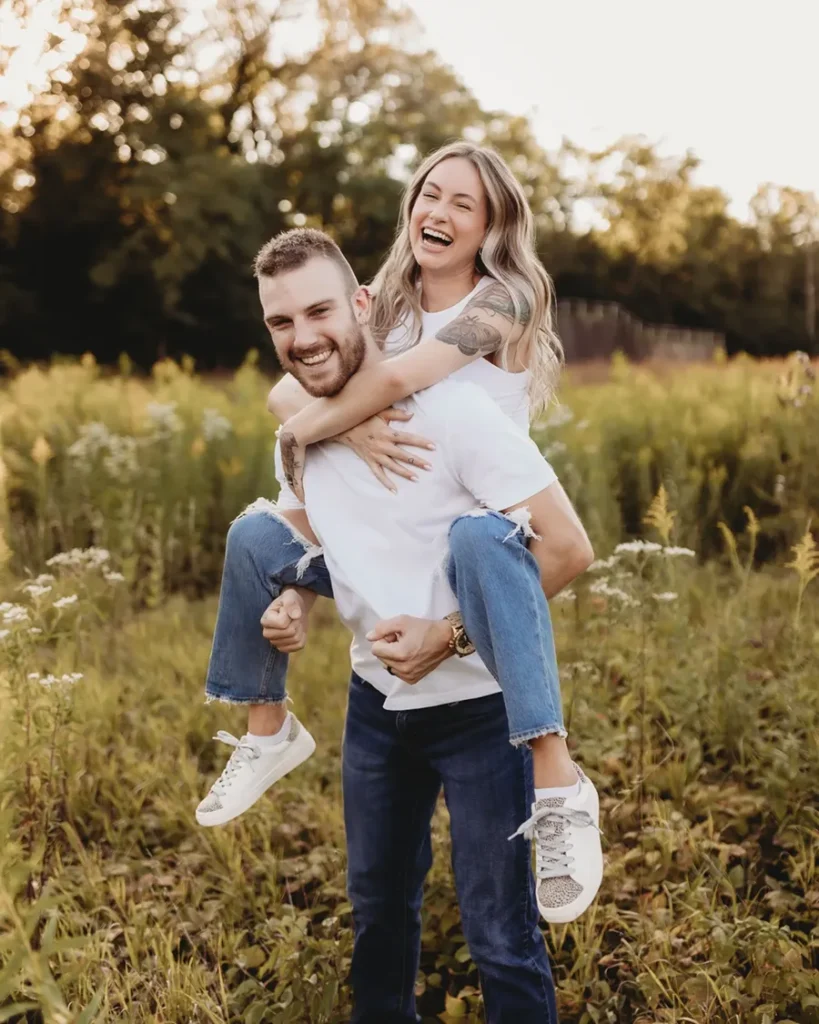 A couple laughing in a Buffalo meadow during a portrait session