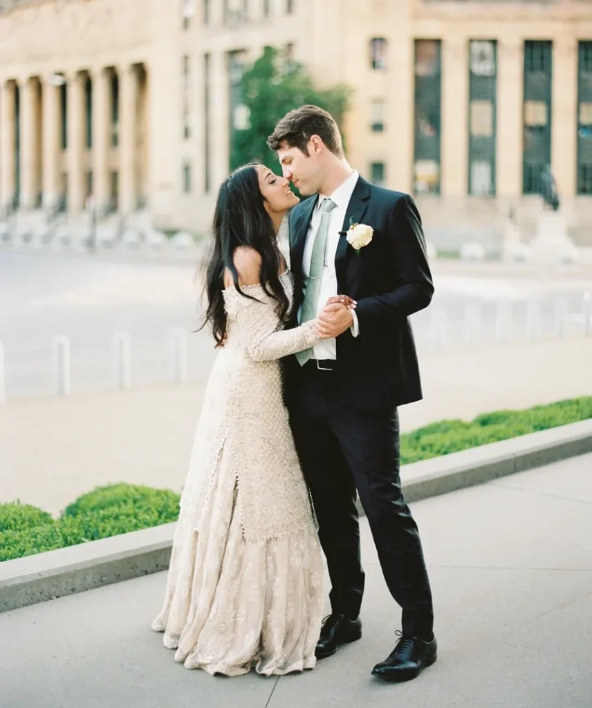 A wedding couple photographed in front of a columned building